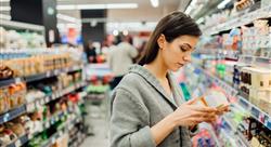 young woman shopping in the supermarket grocery store.Reading ingredients,declaration or expiration