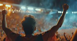 excited fan with arms raised at a basketball game